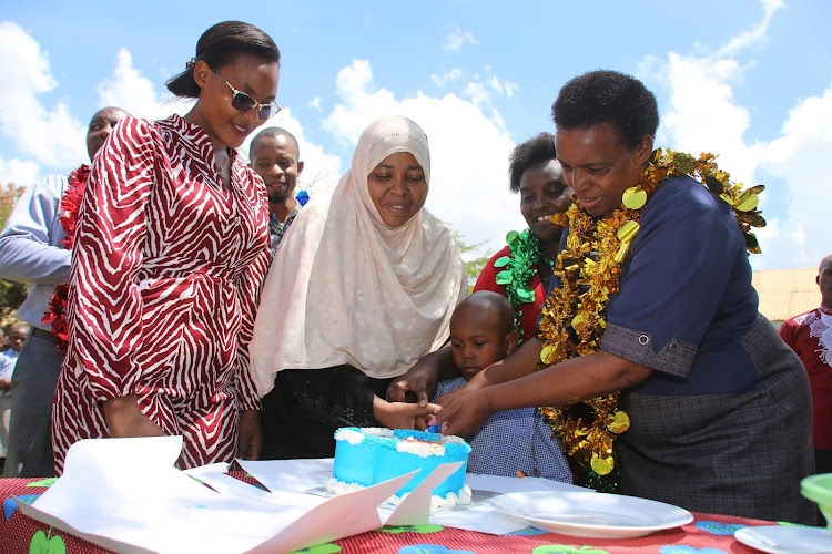 Taita Taveta Deputy Governor Christine Kilalo is assisted to cut a cake to mark the launch of Sh18 million ECDE feeding program on March 13, 2024