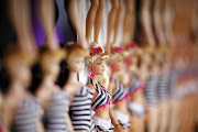 Barbie dolls are lined up on the wall at a Barbie's 50th birthday party at the Barbie's real-life Malibu Dream House in Malibu, California on March 9 2009.