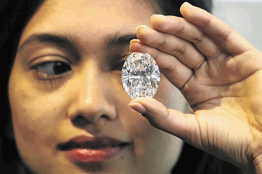 An employee holds a 118.28 carat, flawless D Color Magnificent Oval Diamond at Sotheby's auction house in New York this week. First discovered in deep mines in Southern Africa and chiselled from a huge 299 carat rough, the gem is expected to fetch between $28-million and $35-million at an auction in Hong Kong on October 7.