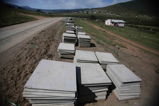 GATHERING DUST: Slabs of the material used to build and erect the toilets are seen here laying on the side of the road in Keiskammahoek. Residents said it has been about three weeks since the material was delivered.