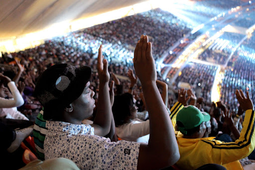 Thousands of Christians raise their hands at the Night of Bliss church service with international pastor known for his healing prayers, Pastor Chris Okhiyalome at the FNB stadium, Johannesburg, South Africa. Okhiyalome is the founder of the church which has amassed a large following around the world.