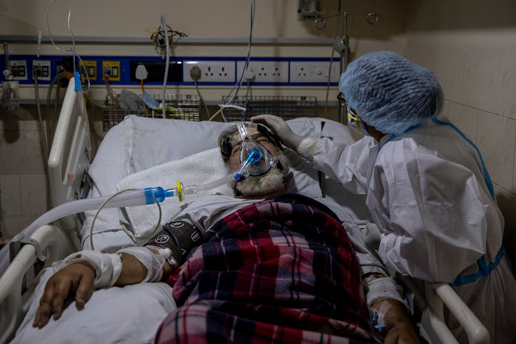 A medical worker tends to a patient suffering from Covid-19 inside the ICU ward at Holy Family Hospital in New Delhi.