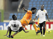 PLAYING TO EMPTY SEATS
      : Ivory Coast's Wilfried Bony, centre, fights for the ball with Angola's Alves de Carvalho during their Afcon  match in Malabo last week.
    
      Photo: REUTERS