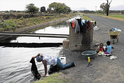 IN AT THE DEEP END: A resident of De Kroon informal settlement, near Brits in North West, does washing in a canal in the absence of clean water from the Madibeng municipality. Incompetence of municipal officials has been blamed for the area's water crisis