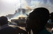 A pick-up truck drives past tear gas fired to disperse Sudanese demonstrators during a protest demanding Sudanese President Omar Al-Bashir to step down in Khartoum, Sudan on April 6 2019. 
