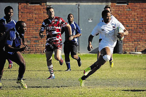 STYLISH WIN: Vuyo Sigingqi runs with the ball in yesterday’s clash between Rhodes University and the University of Zululand at the Old Selbornians ClubPicture: SIB0NGILE NGALWA