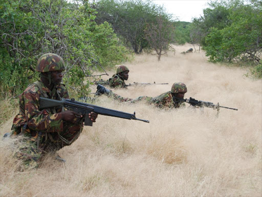 Armed and ready: A file photo of KDF soldiers taking cover as their convoy manoeuvres through the forests of Somalia.Dadaab MP Mohamed Shidiye has urged the government not to withdraw the forces from Somalia.