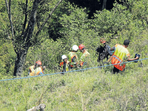 RESCUE MISSION: Rescue teams at the site where a man went over a 100m cliff and was trapped for more than 19 hours in his mangled car in Ngqeleni. The body was retrieved around midday yesterday after rescuers used the jaws of life to cut it free. Top left, An O R Tambo Air Rescue Unit helicopter and another from Fidelity Security Services Picture: SIKHO NTSHOBANE