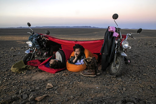Adventurists rest under a makeshift tent on the Monkey Run in Morocco.
