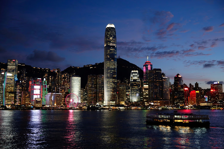 A Star Ferry boat crosses Victoria Harbour in front of a skyline of buildings during sunset in Hong Kong, China. Picture: TYRONE SIU/REUTERS