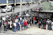 LONG HAUL: Zimbabweans  queue for their papers at the Home  Affairs Department in Johannesburg  Photo: Antonio Muchave