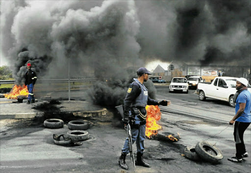UNREST: Residents of Nompumelelo Township in Beacon Bay set tyres alight during a service delivery protest in the area yesterday. Picture: BHONGO JACOB