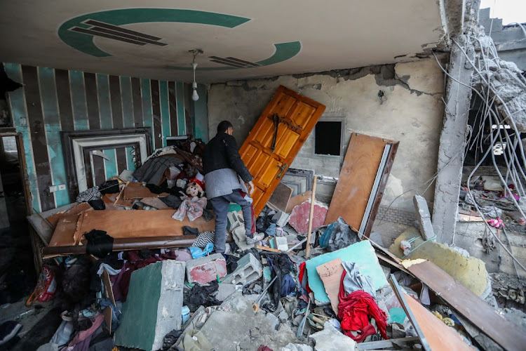 People inspect damage and recover items from their homes following Israeli air strikes on February 27, 2024 in Gaza City, Gaza. As of Tuesday, 29,878 had been killed in Gaza since the start of the war on Oct. 7, according to the territory's health ministry.