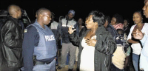 NOWHERE TO GO: Baso Miya tries in vain to get the police to save their house in Umlazi after a bank repossessed and sold it without informing them . Pic. Mhlaba Memela. 28/10/2009. © Sowetan.