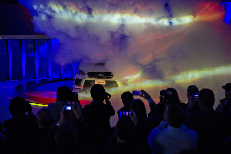 Attendees take photographs as the Subaru STI S209 vehicle is revealed during the 2019 North American International Auto Show (NAIAS) in Detroit, Michigan, US.