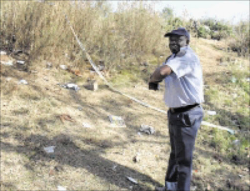 CRIME SCEN: Inspector Moses Maphakela shows where the victim was found. 10/05/2009. Pic. Penwell Dlamini. © Sowetan.