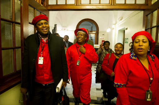 EFF leader Julius Malema and members of the EFF leave the National Assembly during a debate on President Jacob Zuma's state of the nation address in Parliament on June 19, 2014 in Cape Town, South Africa. Malema was asked to leave the National Assembly last night, after refusing to withdraw a remark accusing the ANC of murdering mineworkers in Marikana.