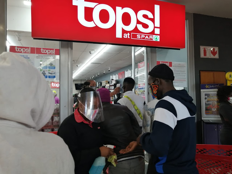 Shoppers queue outside a liquor store in Durban.