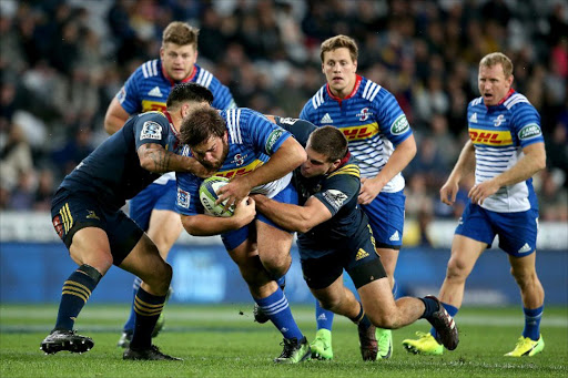 Frans Malherbe of the Western Stormers is tackled by Otago Highlanders' Malakai Fekitoa (front L) and Dillon Hunt (front R) during the Super Rugby match between the Otago Highlanders of New Zealand and the Western Stormers of South Africa at Forsyth Barr Stadium in Dunedin on April 28, 2017.