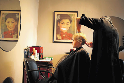 Max Pitman has his hair cut by Moggie Lewis at Summerfield Hair Salon in Parkhurst ahead of his first day as a Grade 1 pupil at The Ridge School in northern Johannesburg Picture: ALON SKUY