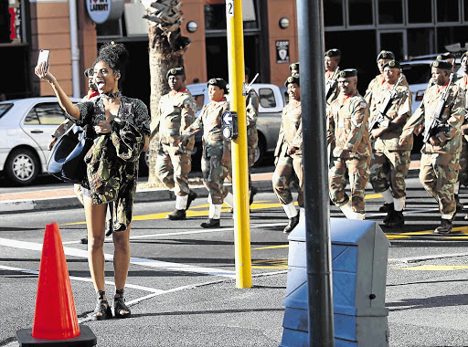 SONA SELFIE: A bystander takes a selfie during the South African Defence Force dress rehearsal in the Cape Town CBD ahead of the State of the Nation Address