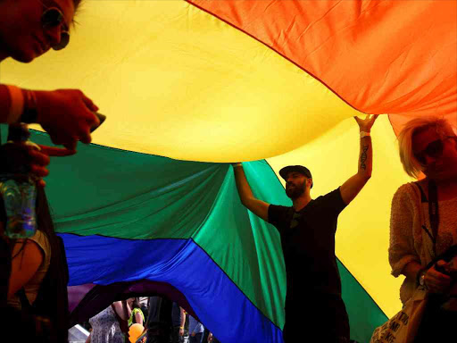 Participants dance under a rainbow flag during an annual LGBT (Lesbian, Gay, Bisexual and Transgender) pride parade in Belgrade, Serbia September 18, 2016. /REUTERS