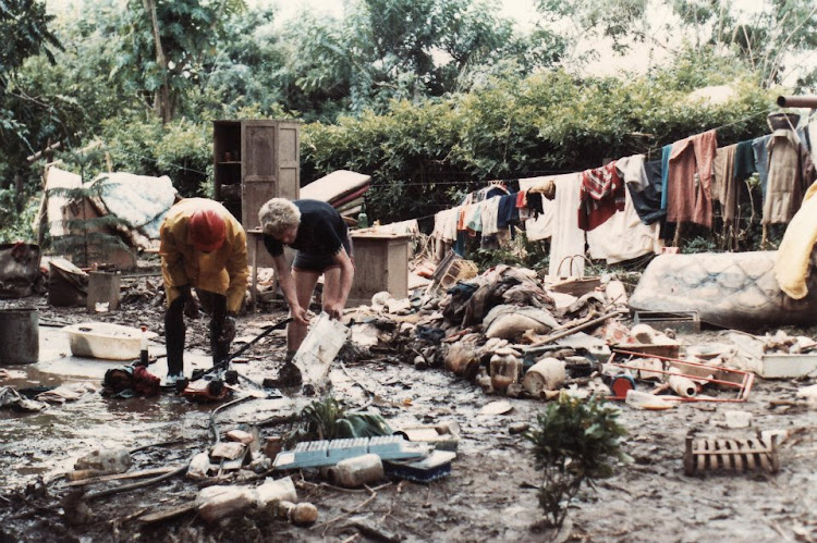 "Our friends picking through the remains of their belongings after the water had receded." Picture: PETER HUGHES