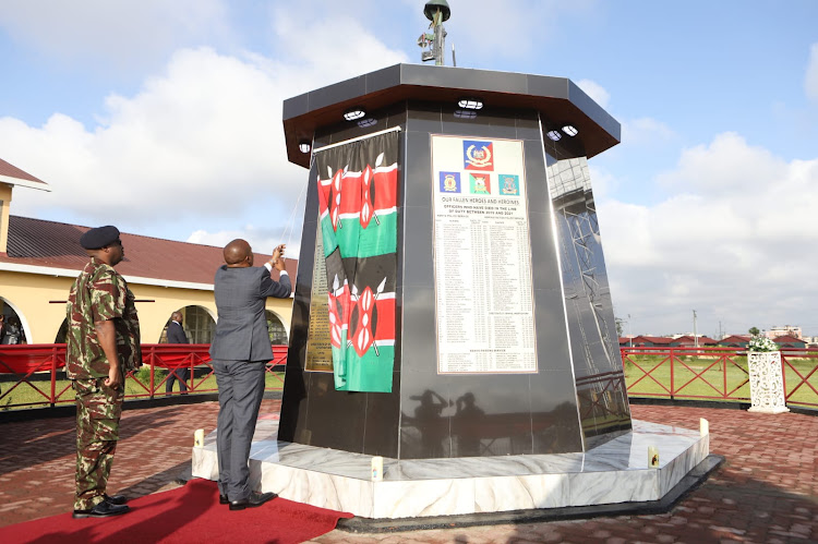 IG Japhet Koome and Interior CS Kithure Kindiki unveil a monument with names of fallen police officers during a memorial service at Embakasi AP training College, Nairobi on Friday, December 16, 2022.