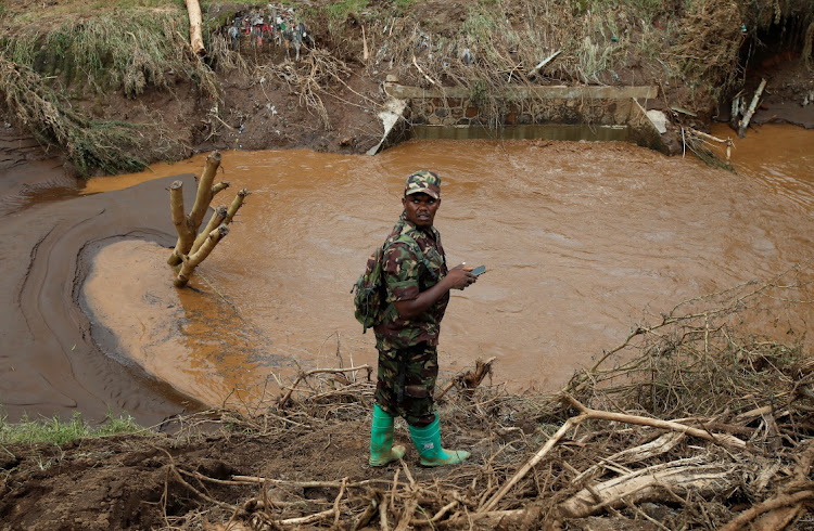 A member of the Kenya Defence Forces stands as they search for the bodies of missing people after flash floods wiped out several homes following heavy rains in Kamuchiri village of Mai Mahiu, Nakuru County, Kenya, on May 1 2024.