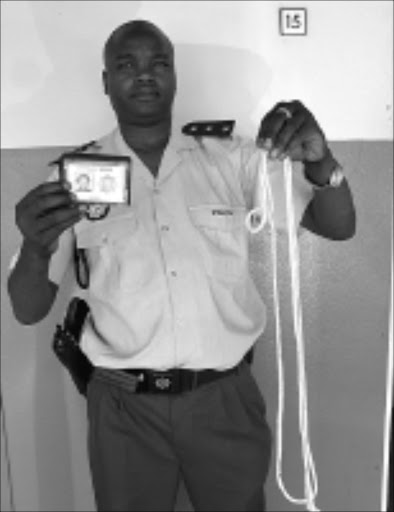 TOOLS OF THE TRADE: Captain Manaka Raphulu shows the rope and police ID used by the gang. 11/12/2008. Pic. Mfundi Mkhulisi. © Sowetan.