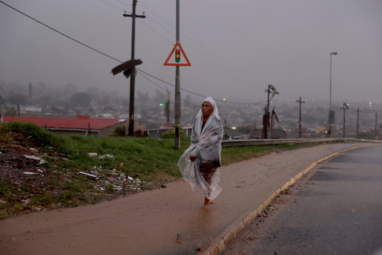 A woman covers herself with a plastic during a heavy rain in Inanda, north of Durban, on June 27 2023. Picture: SANDILE NDLOVU