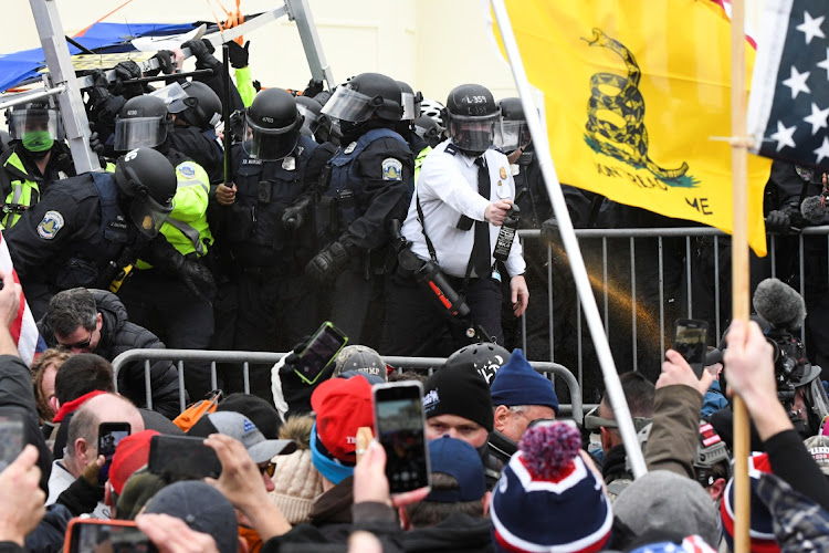 Supporters of US President Donald Trump clash with police officers outside of the US Capitol Building in Washington, on January 6, 2021.