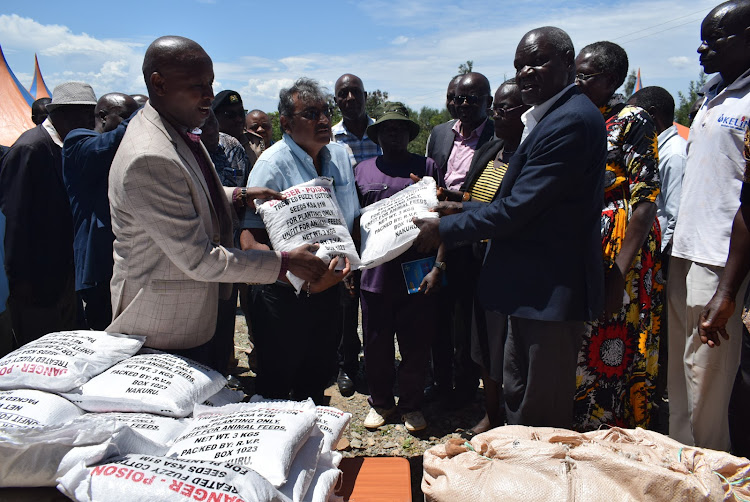 The Principal Secretary for Cooperatives and SMEs Patrick Kilemi, the manager of Rift Valley Products Ltd Sital Panara and Homa Bay Deputy Governor Oyugi Magwanga during distribution of cotton seeds in Homa Bay Town constituency on March 25,2024