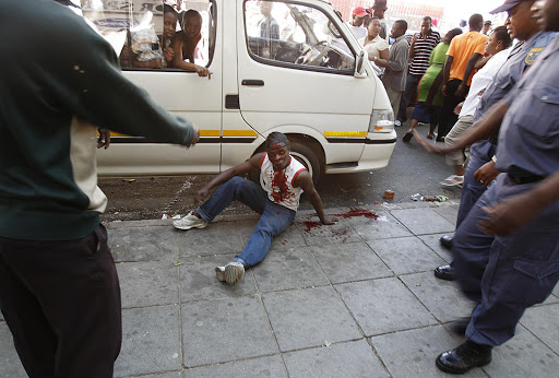 An injured man beaten in a mob justice incident- after The Red Ants evicted illegal tenants from a building on the corner of Jeppe and Nugget Street in Johannesburg. Pic: Alon Skuy. 16/10/2007. © The Times.