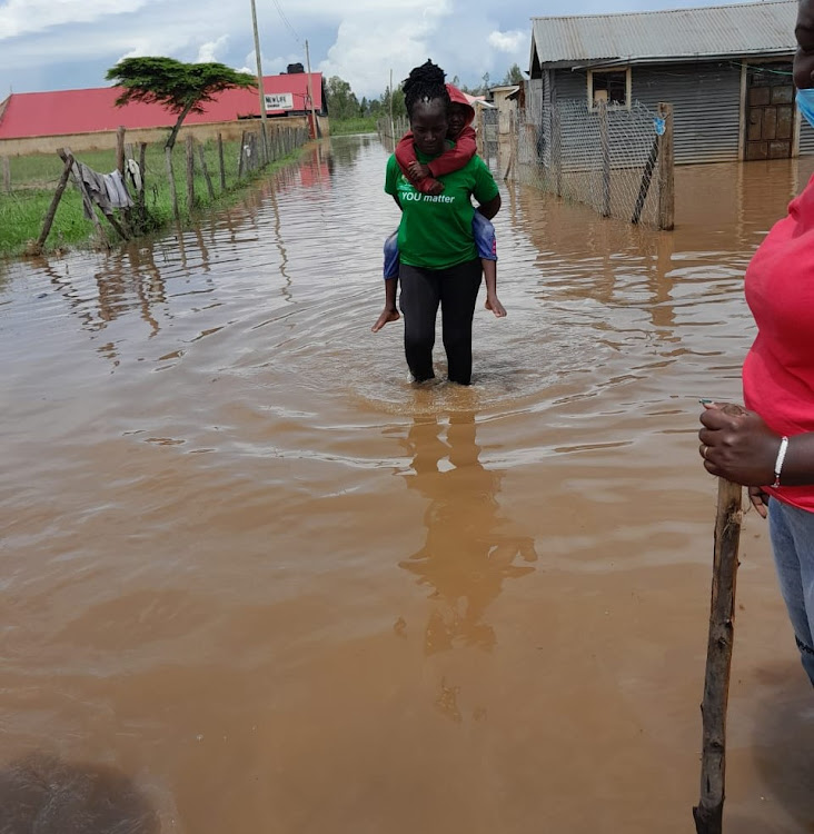 Compassionate Centre for Families Executive Director Sheila Akinyi rescues a stranded child in Dunga, Kisumu Central sub-county on Sunday.