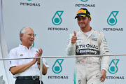 (150329) -- SEPANG, March 29, 2015 (Xinhua) -- Malaysian Prime Minister Najib Razak (L) applauds as Mercedes driver Lewis Hamilton of Britain gestures on the podium after the Malaysian Formula One Grand Prix in Sepang, Malaysia, March 29, 2015. (Xinhua/Chong Voon Chung)