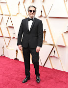 Joaquin Phoenix at the Oscars in the Stella McCartney tuxedo he's reworn throughout the 2020 award season.