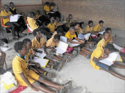 File photo: BAD STATE: Pupils at Matjeni Primary School in Tonga, Mpumalanga, have no desks to sit on and use their laps to support their books in 2010. Photo: Sibongile Mashaba