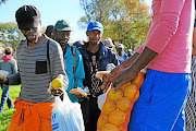 The homeless,  unemployed and families living below the bread line gather in Mayfair, Johannesburg, to collect food parcels  on Sunday./  Dino Lloyd