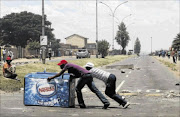 DAYLIGHT THEFT: Locals push a freezer after looting it from a shop, believed to be owned by a foreign national, during service delivery protests in Mohlakeng, west of Johannesburg, recently. The writer says although looting seems to be  common  during service delivery protests, she questions the contention that South Africans are by nature xenophobic  
    
      photo: Siphiwe Sibeko/reuters
