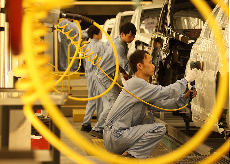 A worker polishes painted vehicles in the paint shop of a plant operated by Dongfeng Peugeot-Citroen Automobile Ltd., the joint venture between Dongfeng Motor Corp. and PSA Peugeot Citroen, in Wuhan, China.