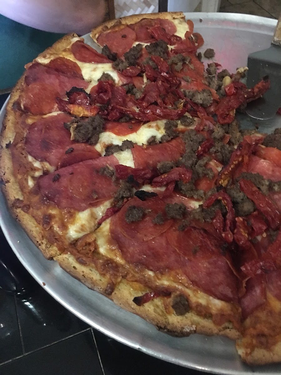 Meat lovers delight with sun dried tomatoes on top.