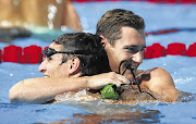 Winner Cameron van der Burgh of South Africa and third-placed compatriot Giulio Zorzi, left, hug after the men's 50m breaststroke final at the world swimming championships in Barcelona last night