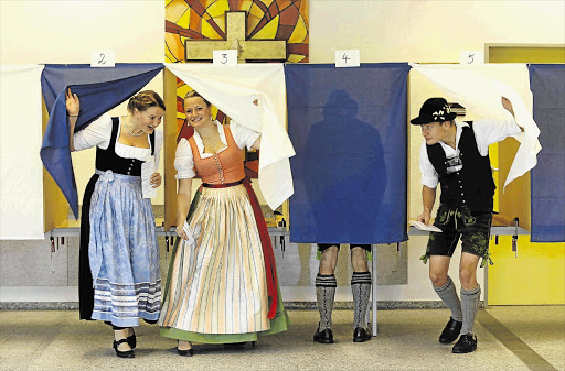 DRESSED FOR THE OCCASION: Voters in traditional Bavarian costume at a polling station in southern Germany yesterday.