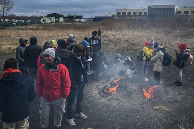 People from the Middle East and African nations warm up around a fire at the Polish-Ukrainian border crossing, February 28 2022. Picture: OMAR MARQUES/GETTY IMAGES