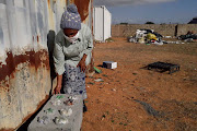 Nosipho Mayinje, a member of the Noziqamo recycling project, with one of the eco-bricks that contain recycled glass bottles and other materials.