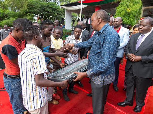 President Uhuru Kenyatta hands over a musical instrument to Super Extra Young Band on April 18 /PSCU