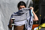 A pro-Palestinian demonstrator covers her face outside Oxford University Museum of Natural History, as students occupy parts of British university campuses to protest in support of Palestinians in Gaza, amidst the ongoing conflict between Israel and the Palestinian Islamist group Hamas, in Oxford, Britain, on May 7, 2024.