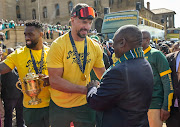 Springbok captain Siya Kolisi (left) and teammate Eben Etzebeth present the Webb Ellis Cup to President Cyril Ramaphosa at the Union Buildings in Pretoria during the Springboks' Rugby World Cup 2023 trophy tour on November 2.