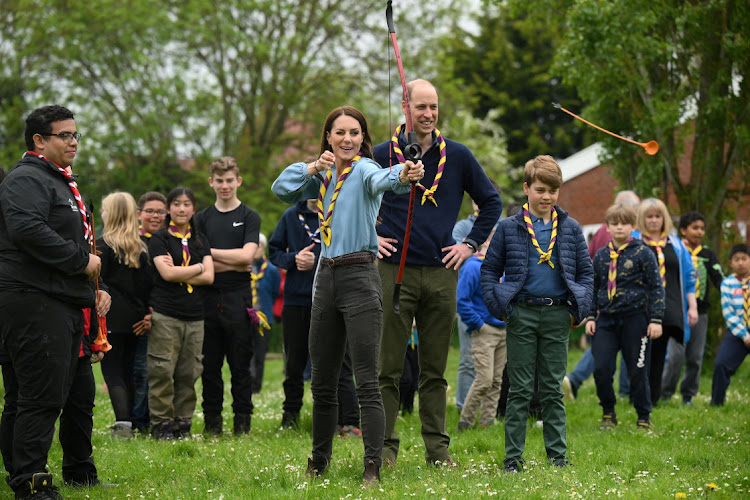 Britain's Catherine, Princess of Wales, tries her hand at archery as Prince William and Prince George react while taking part in the Big Help Out.